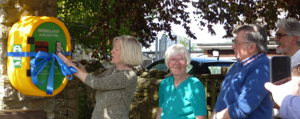 Tessa Munt cuts the ribbon around the new defibrillator.